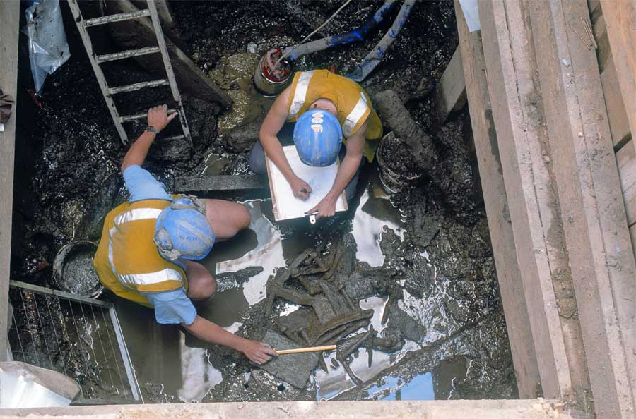  Chris Clarke & Catherine Edwards (Cat) in the base of the east well recording the remains of the heavier-duty wrought iron bucket chain and its burnt box-buckets 