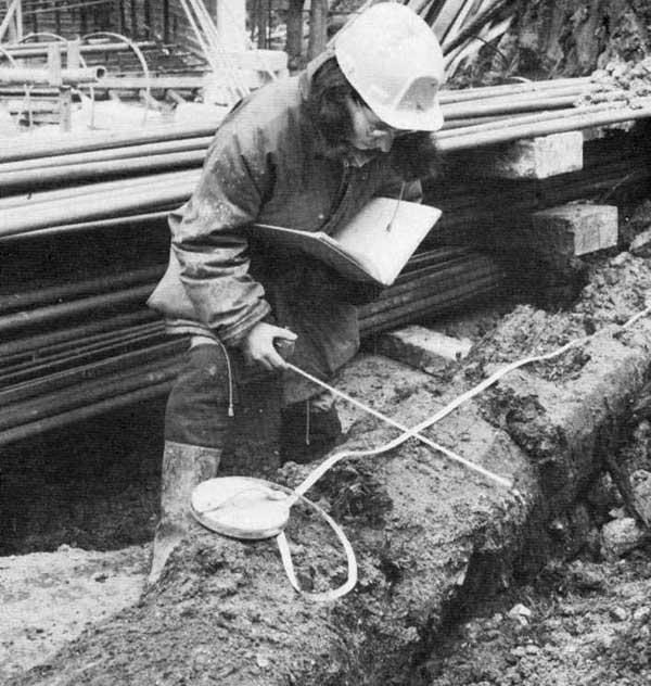 Louise measuring a main timber from the 1st century Roman quay, on the watching brief which followed excavation at Miles Lane (ILA79). As seen in 'Popular Archaeology' June 1982. Photo by Jon Bailey