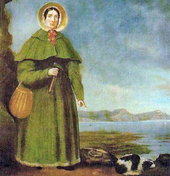 Mary Anning at Lyme Regis, pointing at an even more gargantuan Jurassic ammonite and an extremely rare fossilised spaniel which she has painstakingly chipped out of the rock.
