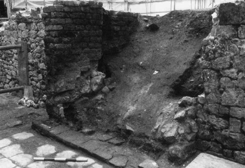 The remains of the staircase walls and limestone floor slabs in Building 7 room b at Monument House (BPL95), looking south-west. The wooden stairs were destroyed in the Great Fire