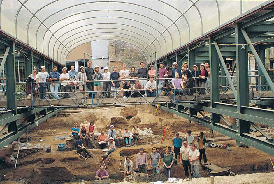 The amphitheatre team towards the end of the main area excavation. The scaffold walkway where most of the archaeologists are standing, provided access across the site through the centre of the massive steel props, and was removed in its entirety to facilitate the aerial photography at the end of the site.