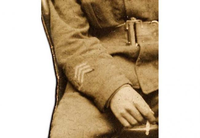 Detail of the inverted ‘service chevrons’ on the lower right-hand sleeve of the seated soldier